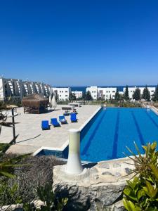 a large swimming pool with a white vase next to a building at Hermes Penthouse Sea Sky & Mountains in Akanthou