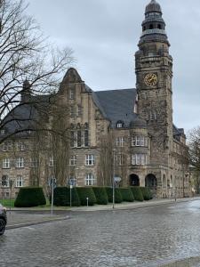 un gran edificio de piedra con una torre de reloj. en Exklusive Stadtwohnung am Elbradweg: Best-Preis-FEWO Rathausblick 1 für max. 3 Pers. inkl. WLAN, Prime Video & Self Check-In, en Wittenberge