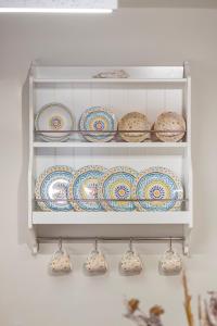 a shelf filled with plates and bowls on a wall at Casa Della vita apartment ,Old Town Rhodes in Rhodes Town