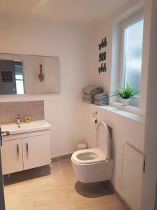 uma casa de banho branca com um WC e um lavatório em Wee Harbour View em Millport