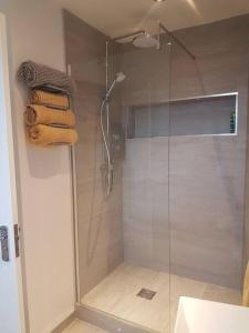 a shower with a glass door in a bathroom at Wee Harbour View in Millport