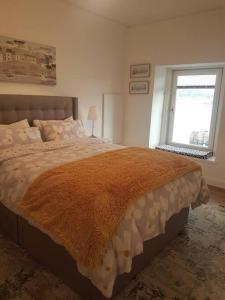 um quarto com uma cama grande e uma janela em Wee Harbour View em Millport