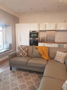 a living room with a couch and a kitchen at Wee Harbour View in Millport