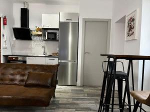 a kitchen with a stainless steel refrigerator and a table at 1A-Precioso Apartamento en pleno centro. A estreno in Alcazar de San Juan