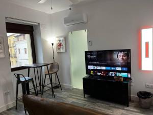 a living room with a flat screen tv and a table at 1A-Precioso Apartamento en pleno centro. A estreno in Alcázar de San Juan