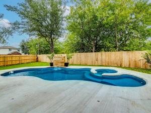 una piscina in un cortile con recinzione in legno di Paradise Oasis Private pool w/Hot Tub 4BR 2.5BA a Pflugerville