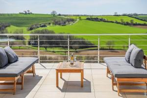 a patio with two couches and a table with a view at VILLA LE BELVEDERE-DESIGN-PISCINE-VUE-GAILLAC in Salvagnac +16 photos