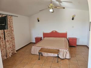 Hotel Rural Portilla de Monfragüe في توريل: غرفة نوم مع سرير مع اللوح الأمامي الأحمر