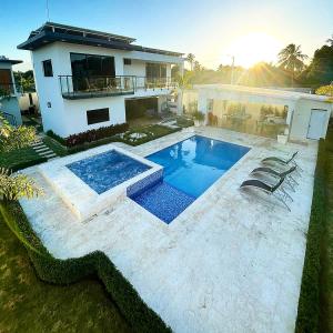 una casa con piscina frente a una casa en Villa Malilisa, en Baní