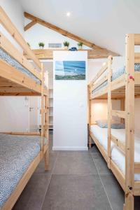 Cette chambre comprend 2 lits superposés et un mur. dans l'établissement Ted Surf House, à Capbreton