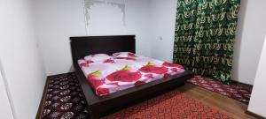 a bed with roses on it in a room at Diyor Hostel in Bukhara
