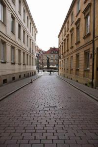 an empty street in a city with tall buildings at Golden Apartments Warsaw - Stylish and Luxury Apartment - Podwale in Warsaw