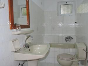 a white bathroom with a toilet and a sink at Thamiris Apartments in Kalyves