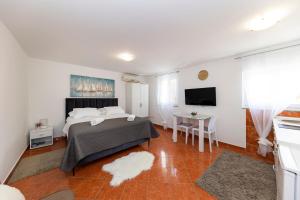 sypialnia z łóżkiem, stołem i telewizorem w obiekcie Apartmani Valentina w mieście Zadar