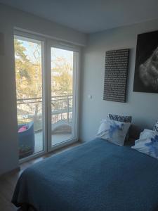 sypialnia z łóżkiem i dużym oknem w obiekcie Kapitańska Apartament w mieście Gdynia