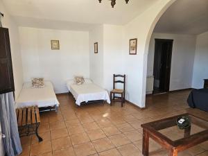 a room with two beds and a table at Hotel Rural Portilla de Monfragüe in Toril