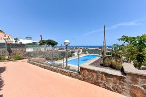 a stone wall with a swimming pool in a yard at Chalet Santa Ana 24 by VillaGranCanaria in Playa del Ingles
