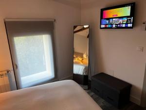 1 dormitorio con cama y espejo grande en 2B-Precioso Apartamento en pleno centro. A estreno, en Alcázar de San Juan