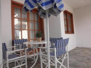 a table and chairs with a table and an umbrella at Thamiris Apartments in Kalyves