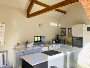 a kitchen with white cabinets and a counter top at Contemporary Luxury Barn Conversion in County Durham in Durham