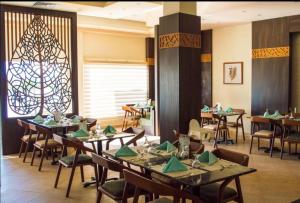 a dining room with tables and chairs and a window at Oyster Bay Resort, One Bedroom Beach Front Apartment, Marsa Alam in Abu Dabbab