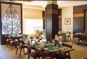 a dining room with tables and chairs and a window at Oyster Bay Resort, One Bedroom Beach Front Apartment, Marsa Alam in Abu Dabab