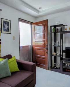 a living room with a couch and a wooden door at 2BR 2BT home with pool between Tagbilaran and Panglao in Dauis