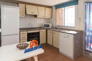 a kitchen with a white refrigerator and a white dishwasher at Ferrobus Duplex in Cullera