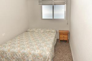 a small bedroom with a bed and a window at Ferrobus Duplex in Cullera +37 photos