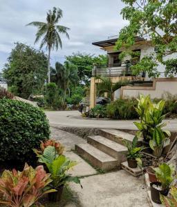 a house with stairs and plants in front of it at 2BR 2BT home with pool between Tagbilaran and Panglao in Dauis