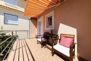 patio z 2 krzesłami i stołem na balkonie w obiekcie Apartmani Valentina w mieście Zadar