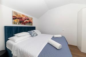łóżko w pokoju z obrazem na ścianie w obiekcie Apartmani Valentina w mieście Zadar