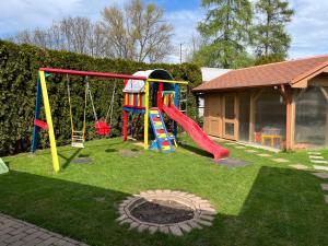 un patio con parque infantil con tobogán en Villa Gracia Patince en Patince