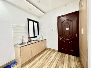 a kitchen with a sink and a wooden door at The Jade Hotel near Tan Son Nhat Airport in Ho Chi Minh City +28 photos