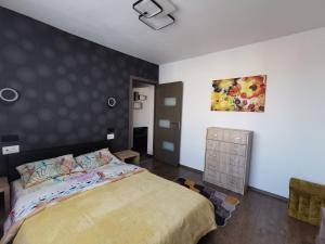 a bedroom with a bed and a painting on the wall at Apartament ASR in Piatra Neamţ