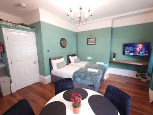 ein Schlafzimmer mit zwei Betten und einem Tisch und Stühlen in der Unterkunft Kings Cross Apartment in London + 5 Fotos
