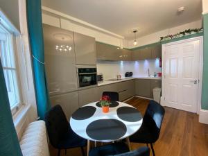 eine Küche mit einem schwarz-weißen Tisch und Stühlen in der Unterkunft Kings Cross Apartment in London