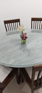 - une table avec deux chaises et un bol de fleurs dans l'établissement HERA HOMESTAY, à Ipoh