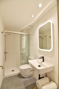 a bathroom with a sink and a toilet and a mirror at Apartament Luna in L'Escala