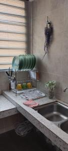 - un comptoir de cuisine avec un évier et un ventilateur dans l'établissement HERA HOMESTAY, à Ipoh