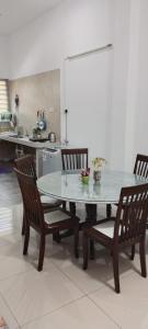 - une table et des chaises dans une cuisine avec un comptoir dans l'établissement HERA HOMESTAY, à Ipoh