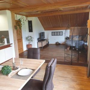 a living room with a wooden table and a room with a dining room at Ferienwohnung Fam. Biechele in Rückholz
