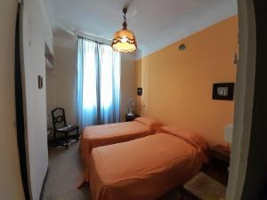 a bedroom with two beds and a chandelier at Agriturismo Olivazzi in Quattordio