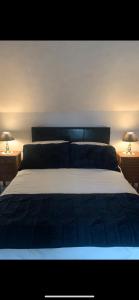 a bedroom with a large bed with two lamps at Dairy Cottage in Swordale