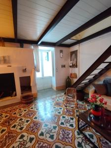 a living room with a tile floor and a staircase at Casa di Nina in Marittima