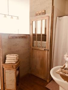 a bathroom with a wooden door and a sink at A La Dolce Vita in Blériot-Plage