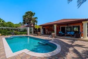 uma piscina em frente a uma casa em GolfCourse Tropical Guest House Private Pool in Tierra del Sol em Palm-Eagle Beach