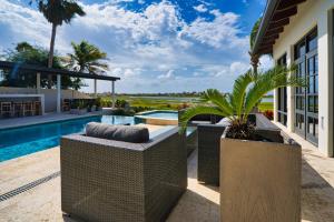 a patio with wicker furniture and a swimming pool at Bird of Paradise Villa in Palm-Eagle Beach