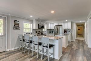 a kitchen with white cabinets and a island with bar stools at Pet-Friendly Lexington Vacation Rental on Lake! in Lexington