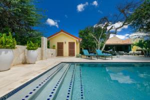 a swimming pool in front of a house at Villa Adelaida in Palm-Eagle Beach
